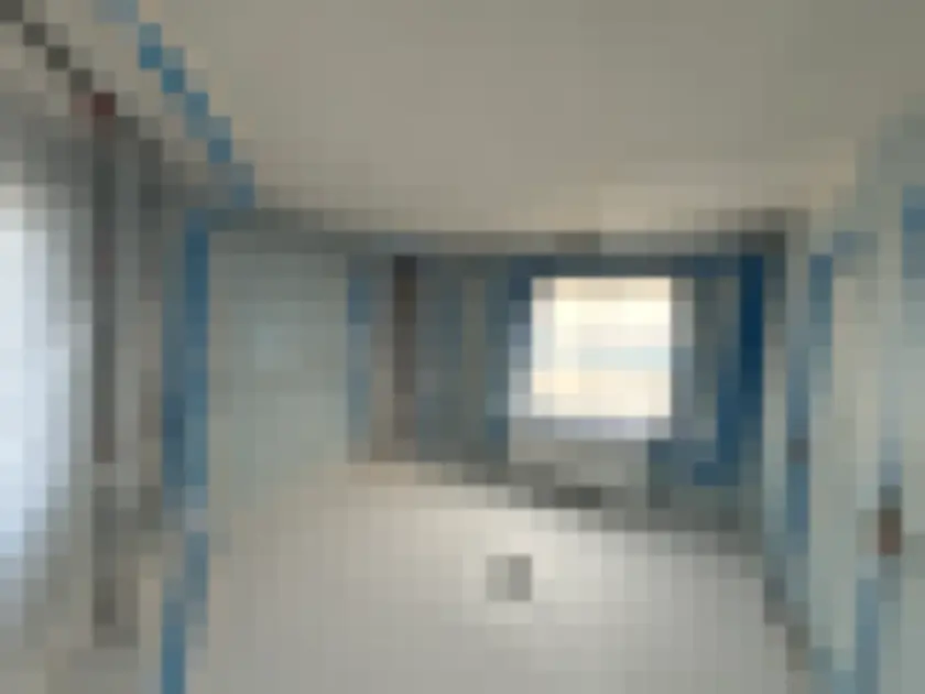 Interior room lined with protective plastic sheeting and blue tape