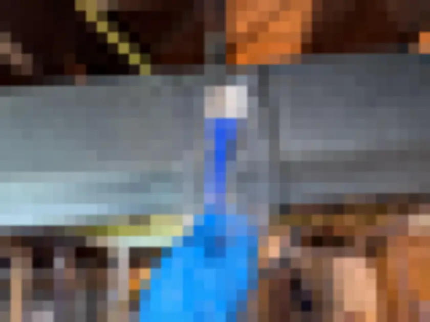 Blue-gloved hand holding sampling media near exposed ductwork