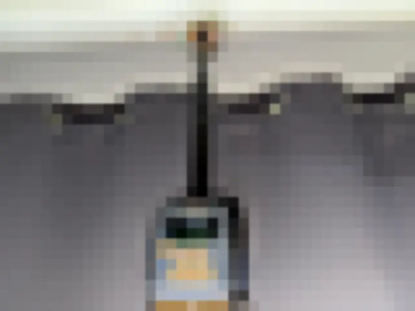Photograph of portable digital meter hanging near indoor curtain and wall