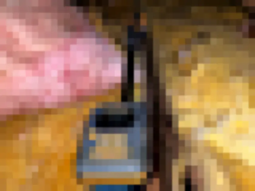 Photograph of digital instrument with probes among fiberglass insulation in attic framing