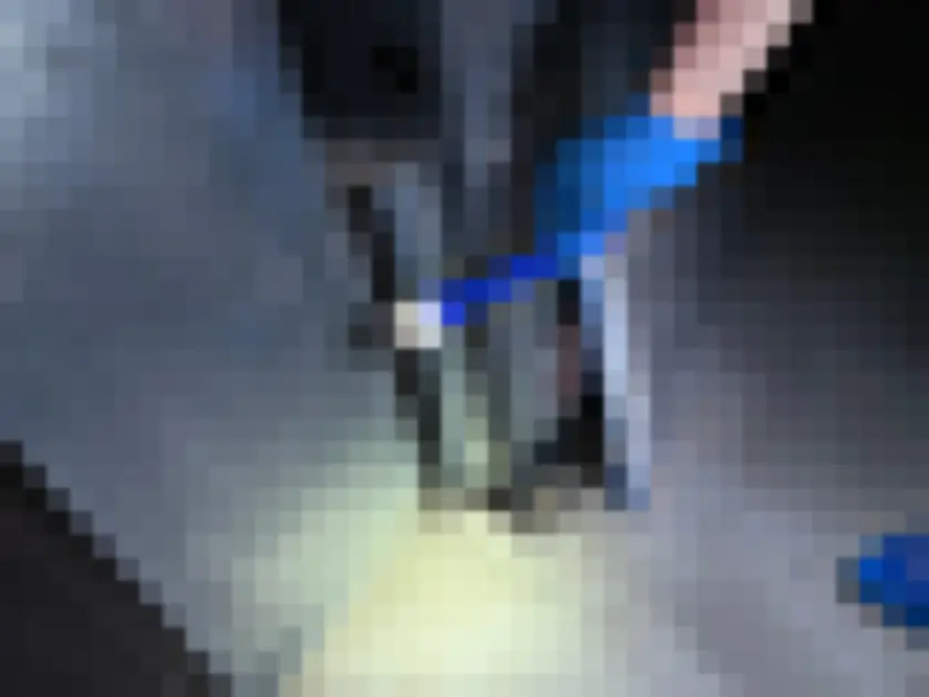 Gloved hand collecting surface material from metal mechanical equipment